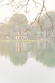 Bare terminalia catappa Cay Bang branches with Tortoise Tower in background, Hoan Kiem Lake