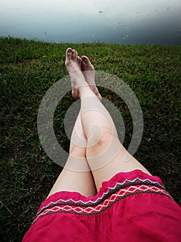 Bare Woman is Feet on The Green Grass. Copy Space. Woman Legs and Feet on Green Grass Near River