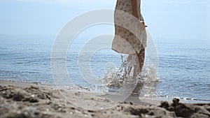 Bare woman feet jumping in ocean water close up. Girl have fun bouncing on waves