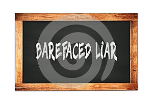 BAREFACED  LIAR text written on wooden frame school blackboard