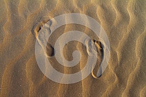 Barefeet footprints on the sand dune