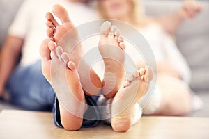 Barefeet of a happy couple lying on a sofa