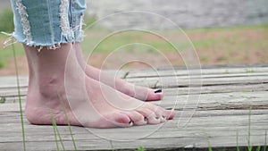 Barefeet of woman starting walking on wooden path