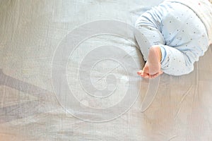 Barefoot baby on bed