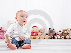 Barefoot baby on white background with cuddly toys - cute little