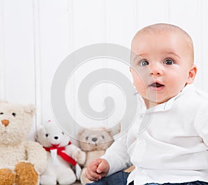 Barefoot baby on white background with cuddly toys - cute little