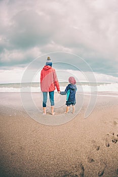 Barefoot boy with mother come into the sea