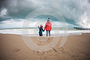 Barefoot boy with mother come into the sea