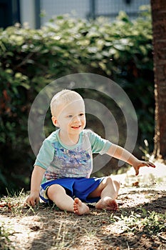 Barefoot boy sits on the sand