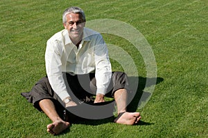 Barefoot businessman sitting on grass