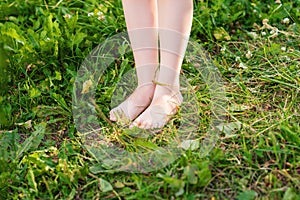 Barefoot of child standing on green grass