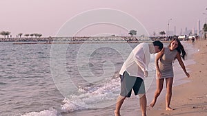 Barefoot couple walks along pictorial sea coast slow motion