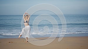 Barefoot dancer performing beach summer day. Tender woman moving sensually