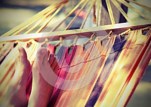 barefoot feet of the little girl while resting on the hammock in