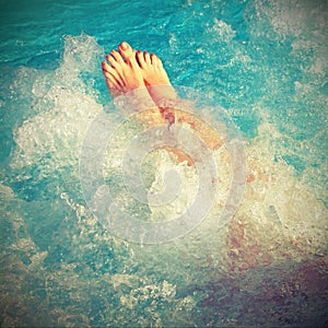 Barefoot female while taking bath in the thermal pool with vinta