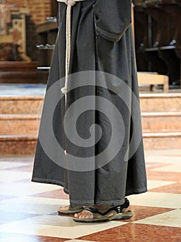 Barefoot friar with sandals in the church