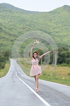Barefoot girl with chamomile bouquet runs along dividing line