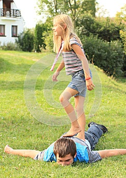 Barefoot girl stepping on young man