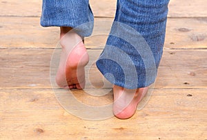 Barefoot girl walking on wooden floor