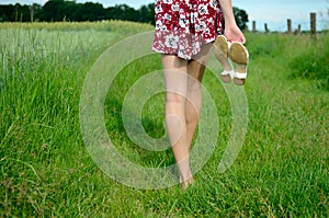 Barefoot girl walks on grass