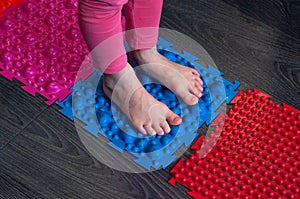 Barefoot girl walks on sensory mats in the sensory integration room photo