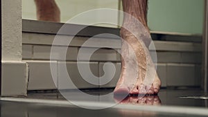 Barefoot human foot stepping on bathroom floor
