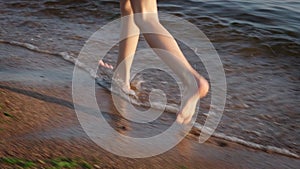 Barefoot kids legs feet running on sand beach ocean shore at sunset. Summer vacation, holiday, family trip. Tourism to