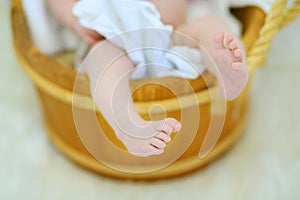 Barefoot legs of cute little baby lying in wooden