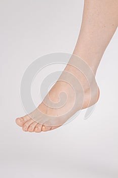 Barefoot and legs isolated on white background. Closeup shot of healthy beautiful female feet. Health and beauty concept