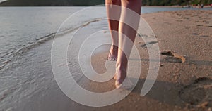 Barefoot legs walking sea shore waves, summer day