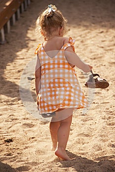 Barefoot little girl walking on beach
