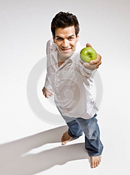 Barefoot man holding fresh green apple