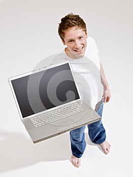 Barefoot man holding laptop