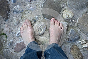 barefoot man on pebblestone surface in outdoor