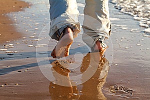 Barefoot man walking on the beach vacation concept