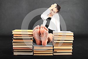 Soles of bare feet of teenage girl on top of old books photo