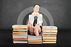 Soles of bare feet of teenage girl on top of old books photo