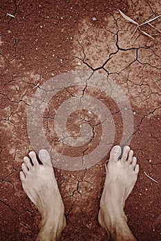 Barefoot standing on dry cracked