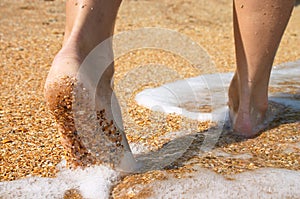 Barefoot in surf on sand coast