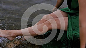 Barefoot woman enjoying the splashing of waves on the water, relaxing by the sea in summer, vacation, freedom, lifestyle