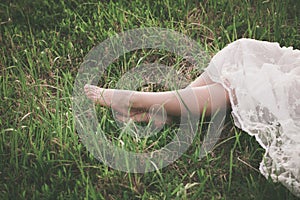 Barefoot woman legs on grass