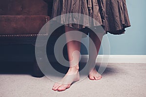 Barefoot woman standing by sofa