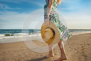 Barefoot woman walking on the ocean beach sand and enjoy the vacation during the tourist trip to the tropical island