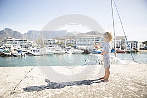 Barefooted Child Points to Luxury Yacht in Harbour