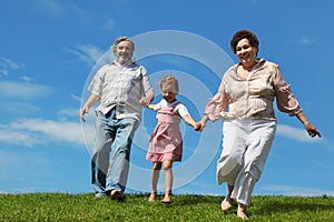 Barefooted little girl and grandparents running