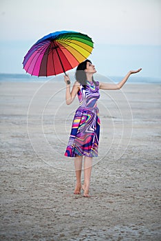 Barefooted woman with colorful umbrella