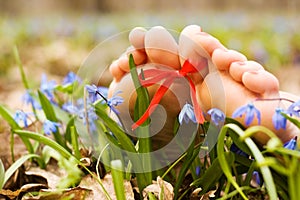 Barefooted woman's feet in flowers. Ribbon bow