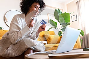 Bargain. Excited, happy African American woman shop online during sale season using laptop and credit card. Copy space.