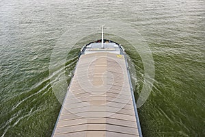 A barge carrying coal with a covered hold on the River Rhine in Germany. Transport of coal and solid fuel, view from above.