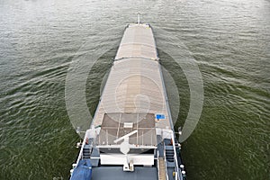 A barge carrying coal with a covered hold on the River Rhine in Germany. Transport of coal and solid fuel, view from above.